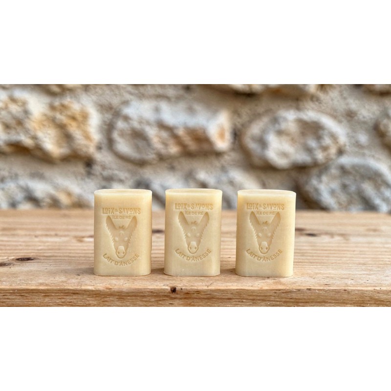 lot de 3 savons au lait d anesse sur une planche devant un mur en pierre