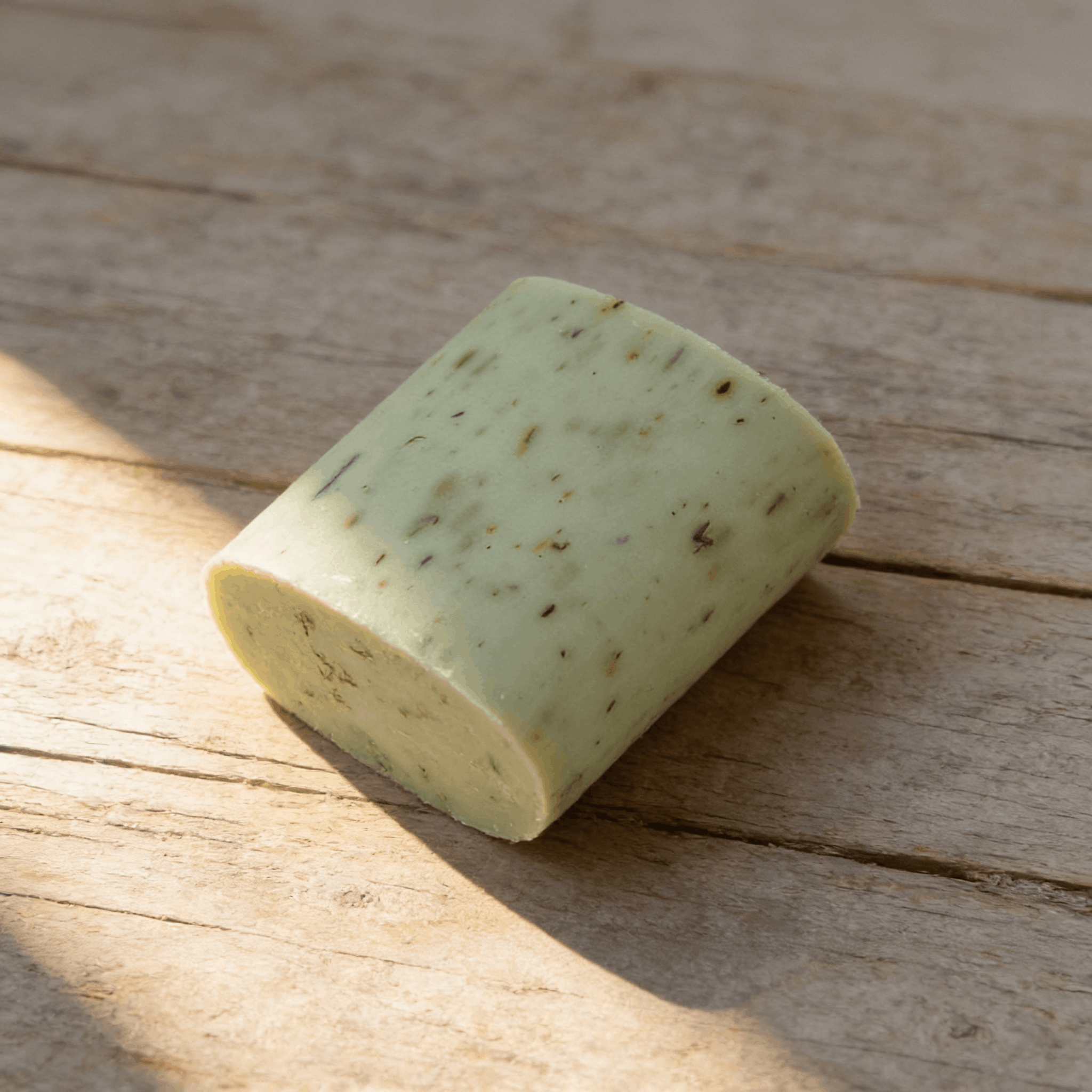 Savon au thym anti-odeur artisanal posé sur une surface en bois clair